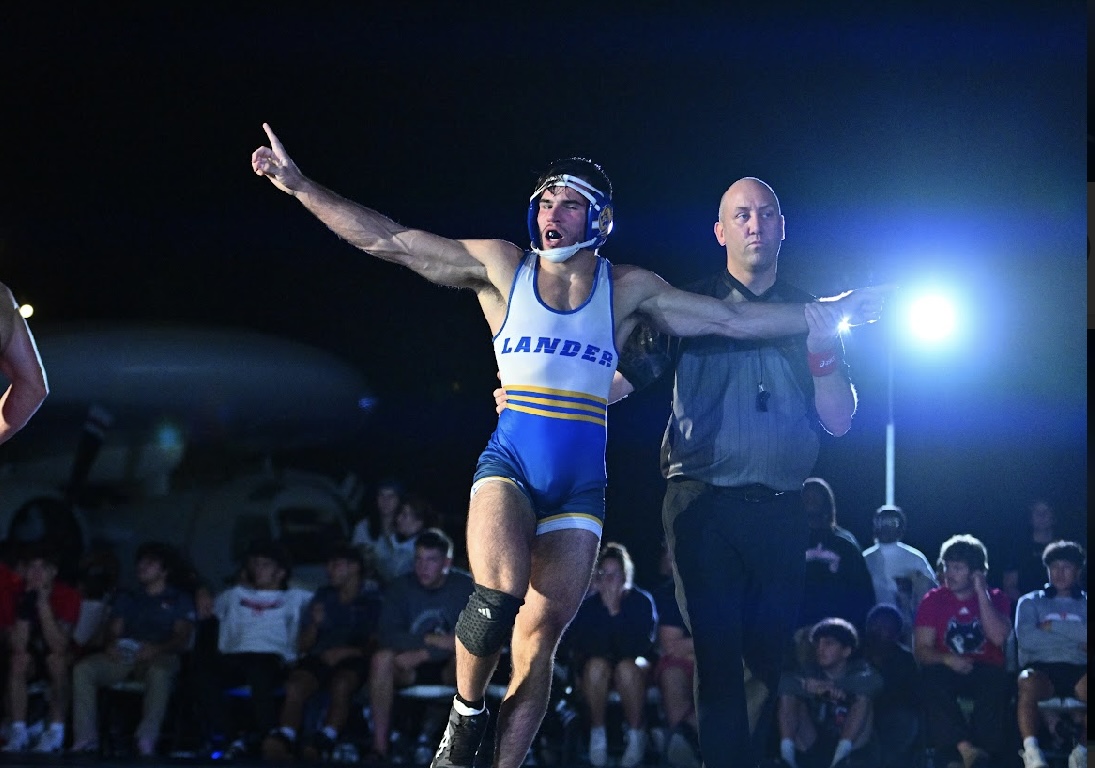 Coach Nate with his hand raised after a collegiate match